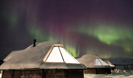 Glass cabins with Northern Lights above