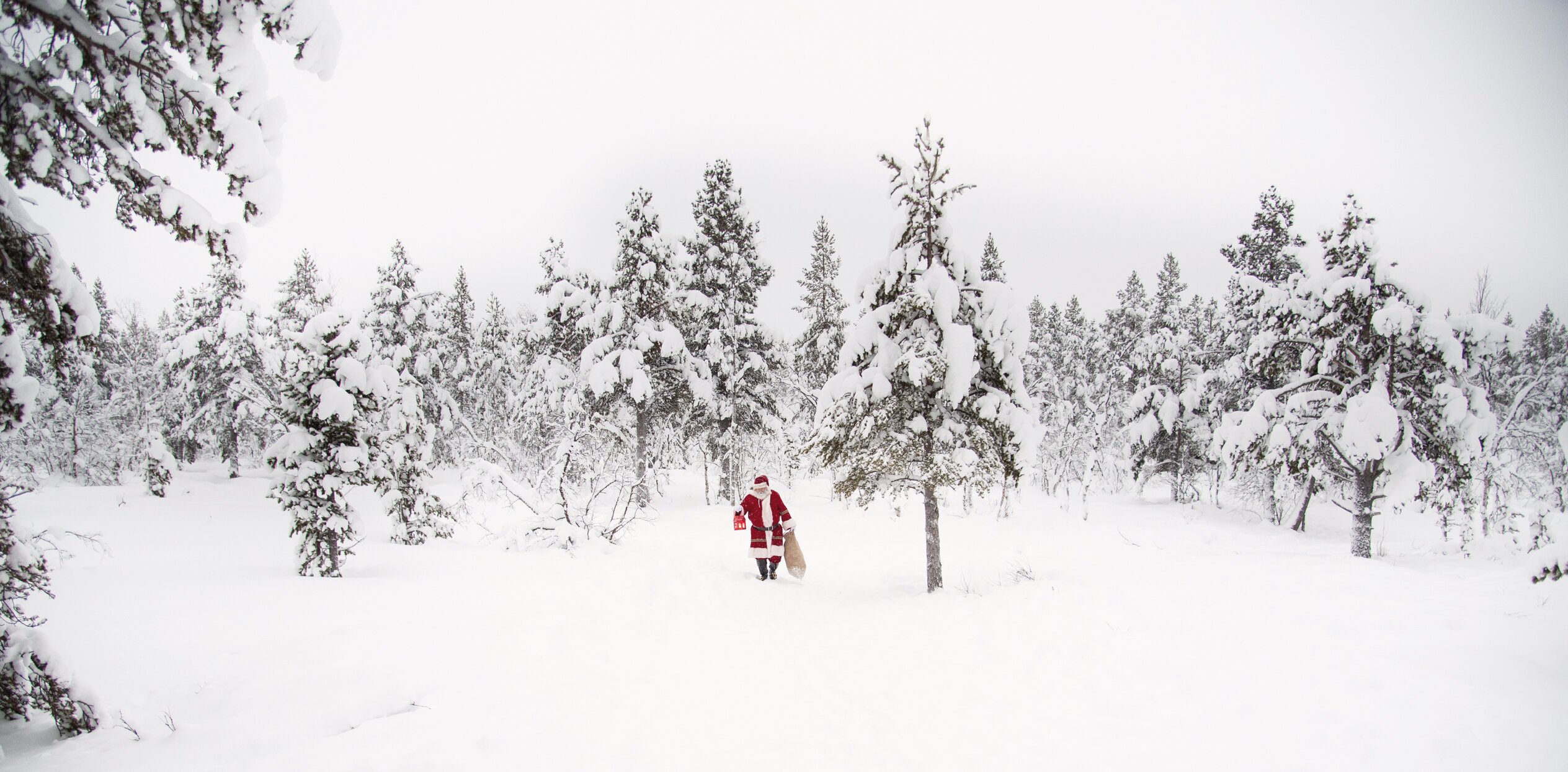 Santa in the snow with a bag of presents
