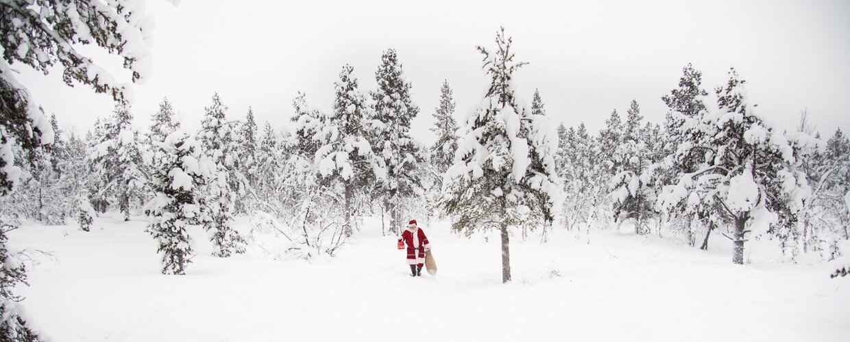 Santa in the snow with a bag of presents