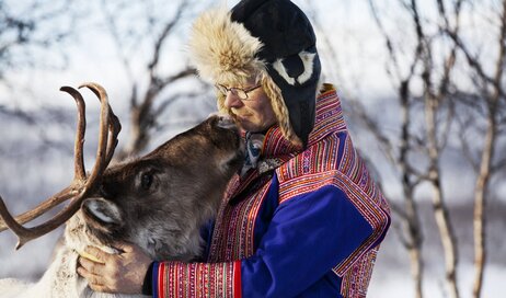 A Sami herder with a reindeer in Finnish Lapland