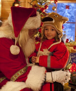 A girl shares her Christmas wishes with Santa