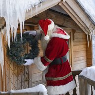 Santa placing a wreath on his cabin