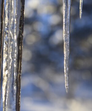 Giant icicles line the roof of a cabin