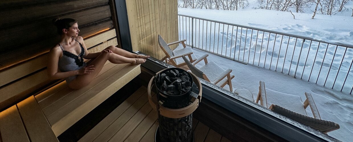 A woman enjoy the view from the sauna at Cahkal Hotel with its floor-to-ceiling windows