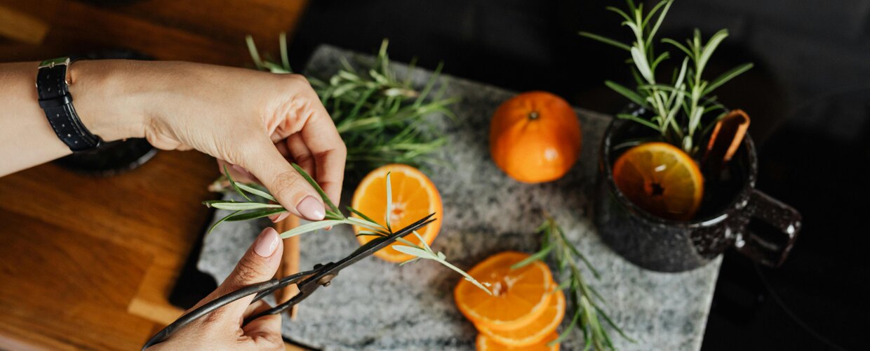 A steaming mug of glogi being made with orange slices and other garnishes