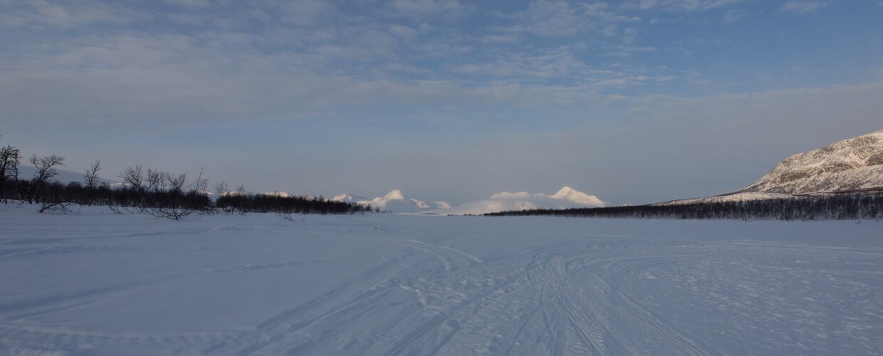 A vast expanse of frozen terrain near Kilpisjarvi, Finland with Saana Fell lingering on the horizon
